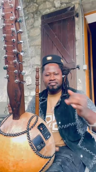 Sako Wana, artiste malien, joue de la kora devant une façade en pierre lors de la promotion de Sagaly 2026 à Villeurbanne, le 17 octobre 2026